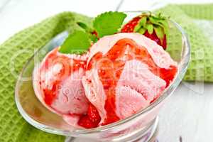 Ice cream strawberry with syrup in glass on board