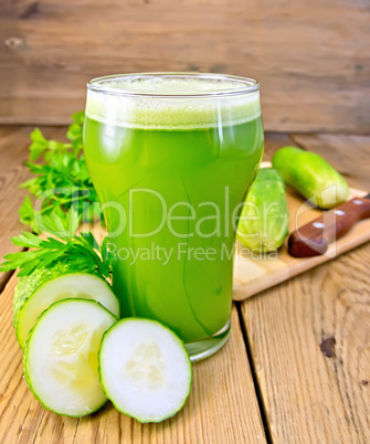 Juice cucumber in tall glass on board with knife