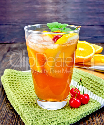Lemonade with cherry in glassful on dark board
