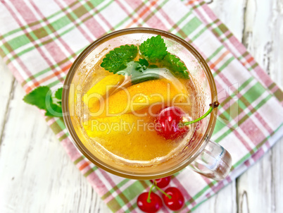 Lemonade with cherry in wineglass on board top