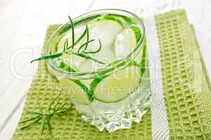 Lemonade with cucumber and rosemary in glassful on board