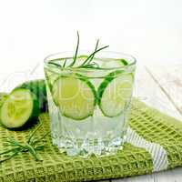 Lemonade with cucumber and rosemary in glassful on napkin and bo