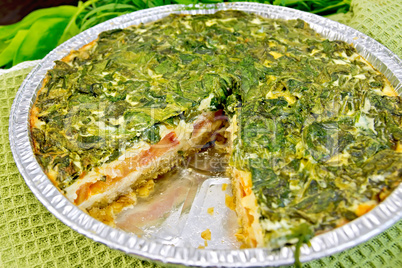 Pie celtic with spinach and tomatoes in form of foil on board