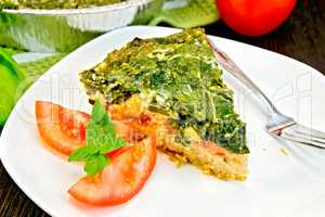 Pie celtic with spinach and tomatoes on table