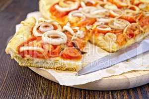Pie with onions and tomatoes on parchment