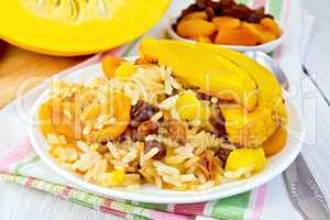 Pilaf fruit with pumpkin in white plate on board