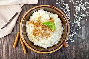 Rice porridge with cinnamon in bowl on board top