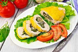 Roll chicken with spinach and tomatoes on light board