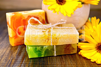 Soap homemade with calendula and mortar on board
