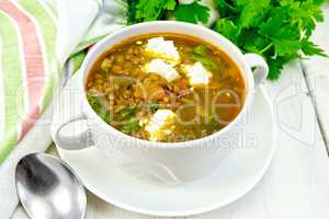 Soup lentil with spinach and cheese on light board