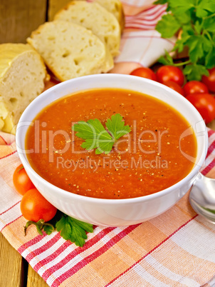 Soup tomato with bread on napkin and board