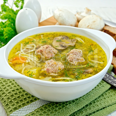 Soup with meatballs and noodles in bowl on napkin