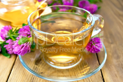 Tea with clover in cup and teapot on board