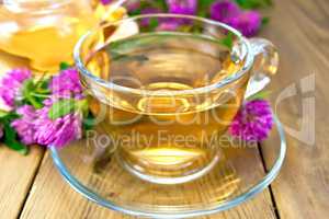 Tea with clover in cup and teapot on board