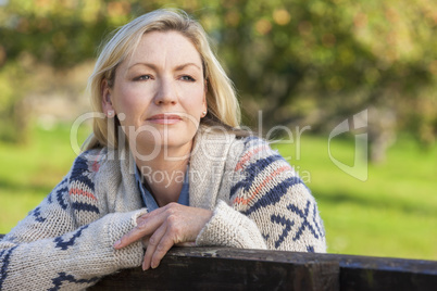 Attractive Thoughtful Middle Aged Woman Resting on Fence