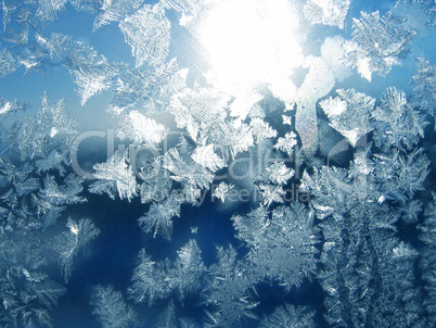 Ice pattern and sunlight on winter glass