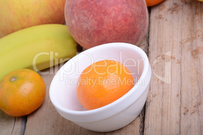 Mandarin Apples Bananas Peach on wooden plate