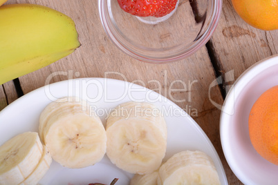 healthy strawberry and bananas slices on wooden background