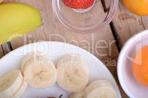 healthy strawberry and bananas slices on wooden background