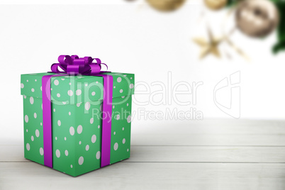 A green christmas present with purple ribbon