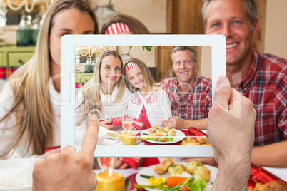 Composite image of hand holding tablet pc