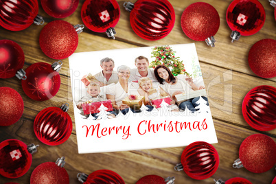 Composite image of christmas baubles on table