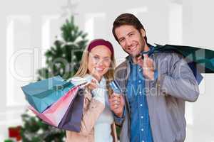Composite image of smiling couple with shopping bags in front of