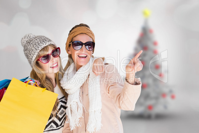 Composite image of beautiful women holding shopping bags pointin