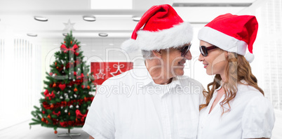 Composite image of festive couple smiling at each other