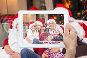 Composite image of hand holding tablet pc