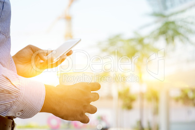 Businessman drinking hot coffee and using smartphone