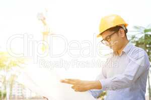 Asian Indian male contractor engineer reading blueprint