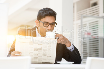 Business people drinking hot coffee and reading newspaper at caf