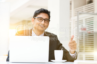 Business man using laptop computer at cafe thumb up