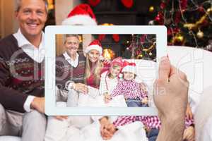 Composite image of hand holding tablet pc