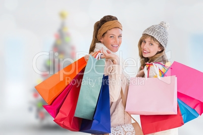 Composite image of beautiful women holding shopping bags looking