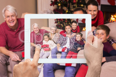 Composite image of hand holding tablet pc