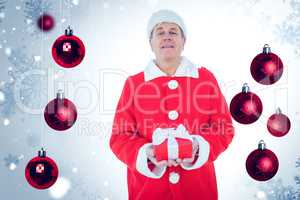 Composite image of festive man holding gift