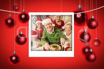 Composite image of grandfather in santa hat carving chicken at c