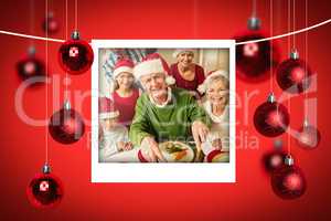 Composite image of grandfather in santa hat carving chicken at c