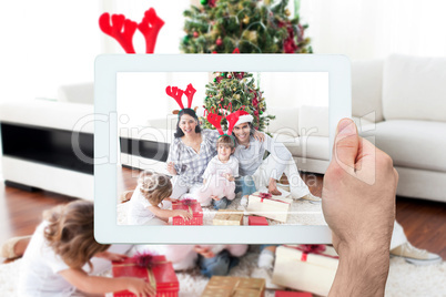 Composite image of hand holding tablet pc