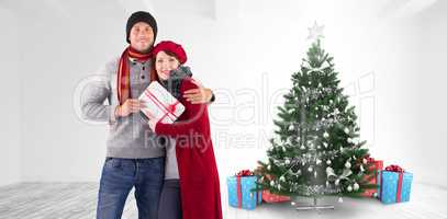 Composite image of couple smiling and holding gift