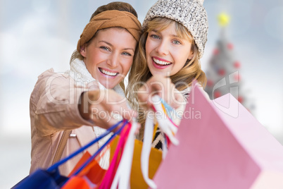 Composite image of smiling women looking at camera with shopping