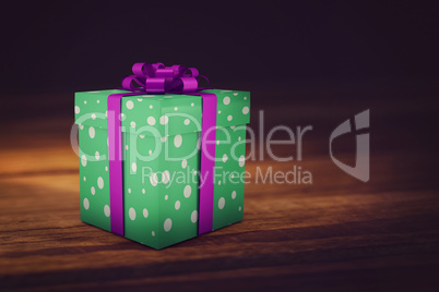 A green christmas present with purple ribbon