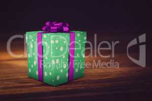 A green christmas present with purple ribbon