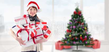Composite image of woman holding lots of presents