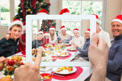 Composite image of hand holding tablet pc