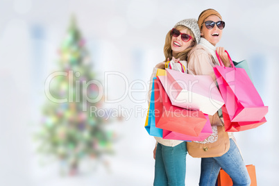 Composite image of beautiful women holding shopping bags looking