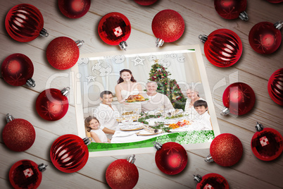 Composite image of christmas baubles on table