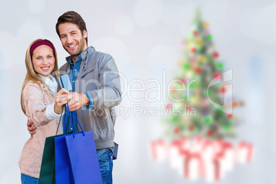 Composite image of smiling couple showing credit card and shoppi